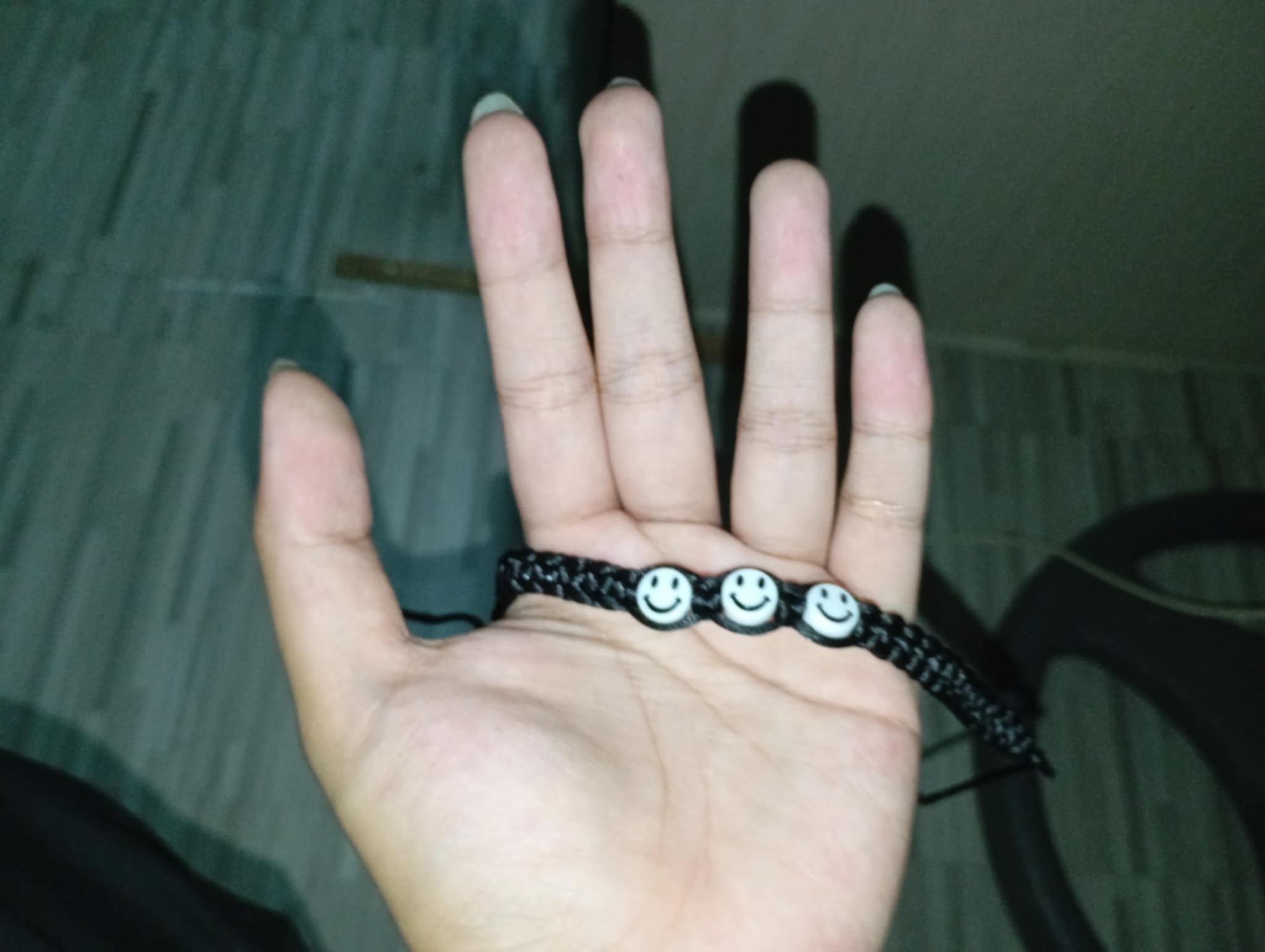 this is a bracelet that used black thread and black and white smiley beads, its feels slippery yet its alright i guess, the best way
                                                  i could describe the color is that it feels shocking, it is so simple yet it still makes energy rush down your nerves